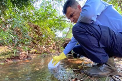 Homem pegando água em um rio